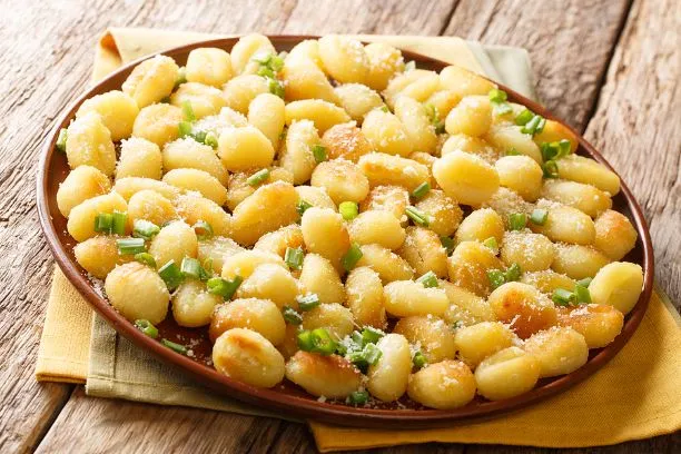 Hausgemachte Kartoffelgnocchi Hausgemachte Kartoffelgnocchi mit Parmesan und Schnittlauch bestreut