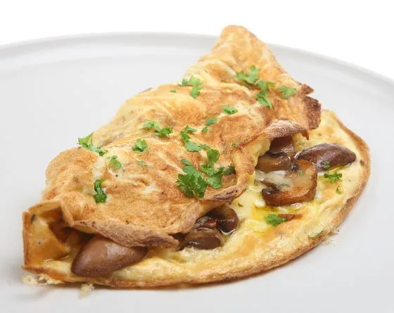 Omelette mit Champignons Hier wird ein auf klassische Art zubereitetes Eieromelette mit zuvor gedünsteten Champignons gefüllt