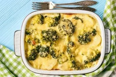 Kartoffel-Brokkoli-Auflauf werden vorgekochte Pellkartoffeln, Brokkoli, Knoblauch und geriebener Käse mit einem Eier/Milchguss vermisch