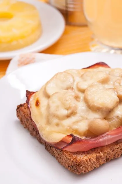 Toast Hawaii mit Bananenscheiben überbackener Toast, der in Westdeutschland in den 1950er Jahren populär wurde