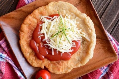 Langos mit Tomatensauce und geriebenen Käse